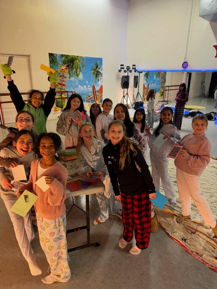 Dancers in pajamas making crafts together at a studio sleepover