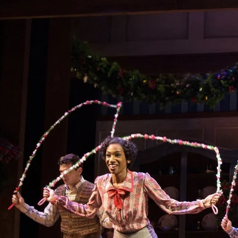 Paige Williams mid-number in Holiday Inn, swinging garland ropes with a partner behind her