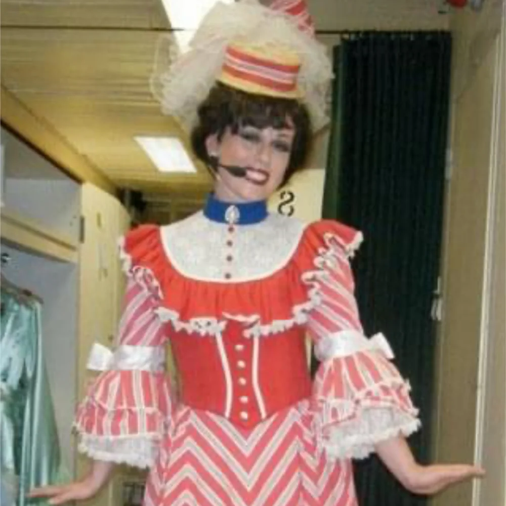 Courtney Reed backstage in a red and white striped period costume and matching hat