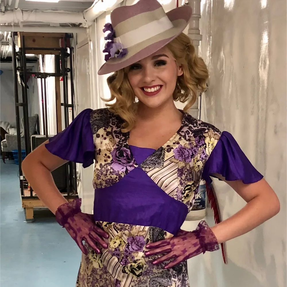 Renee Griese in a purple period costume and straw hat for Crazy For You
