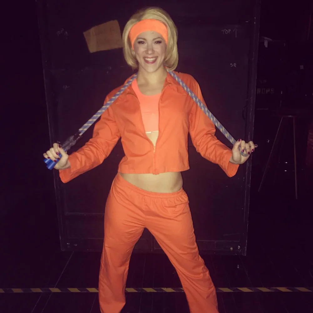 Corinne Holland in an orange tracksuit and headband in costume for SpongeBob the Musical