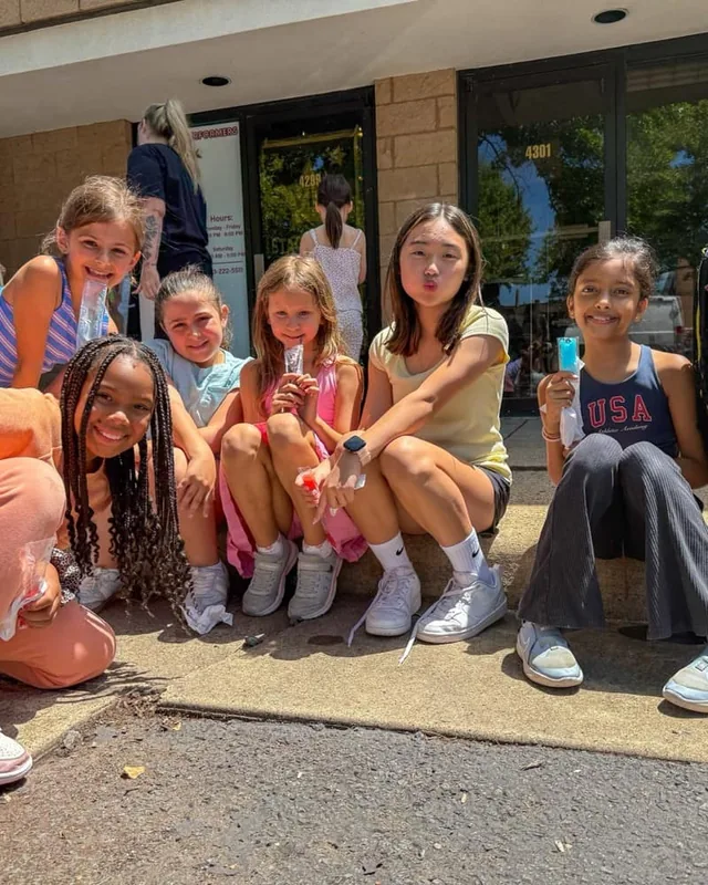 Encore dancers sitting together on the studio steps