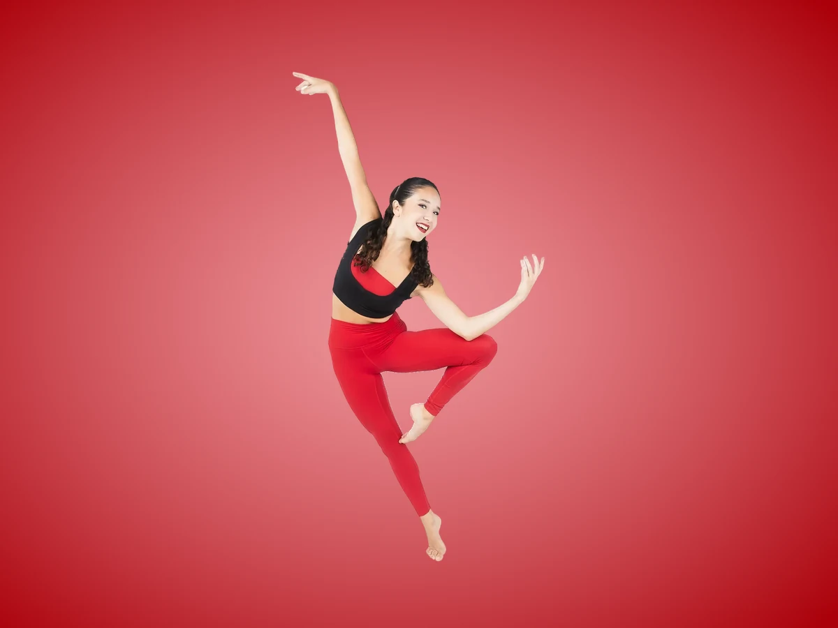 Encore dancer in red leggings and a black crop top in a contemporary pose