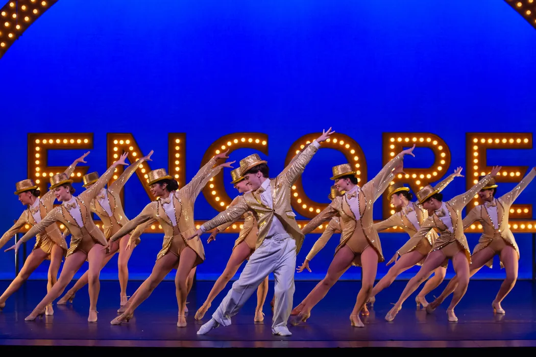 The ETAP ensemble performing in front of the lit ENCORE sign
