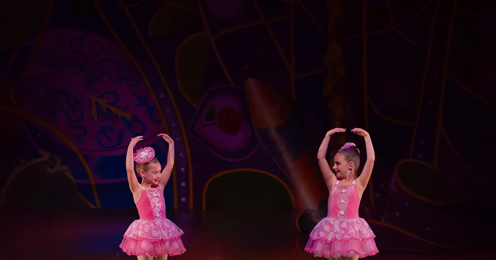 Two young Encore Performers ballerinas in pink tutus posing on stage