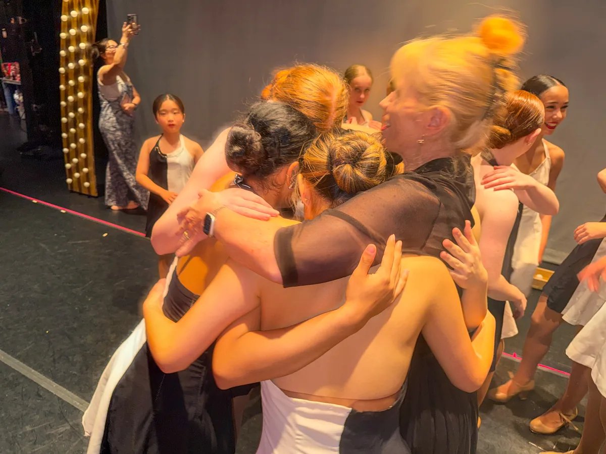 Dancers in gold costumes celebrating together at the end of the show