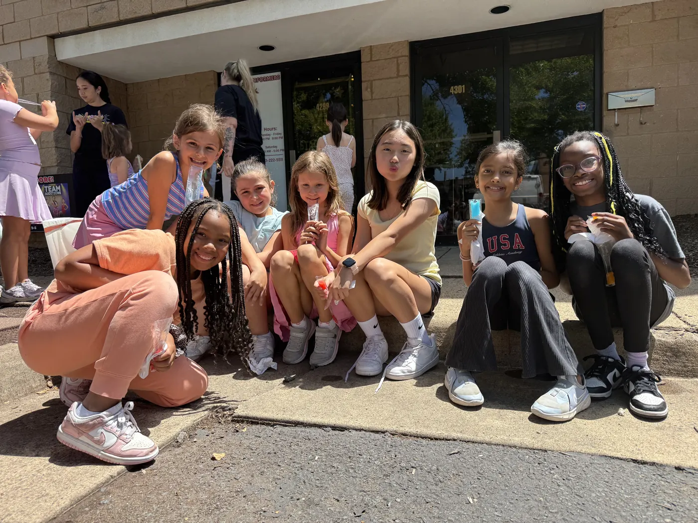 A group of young campers with face paint smiling together in the studio