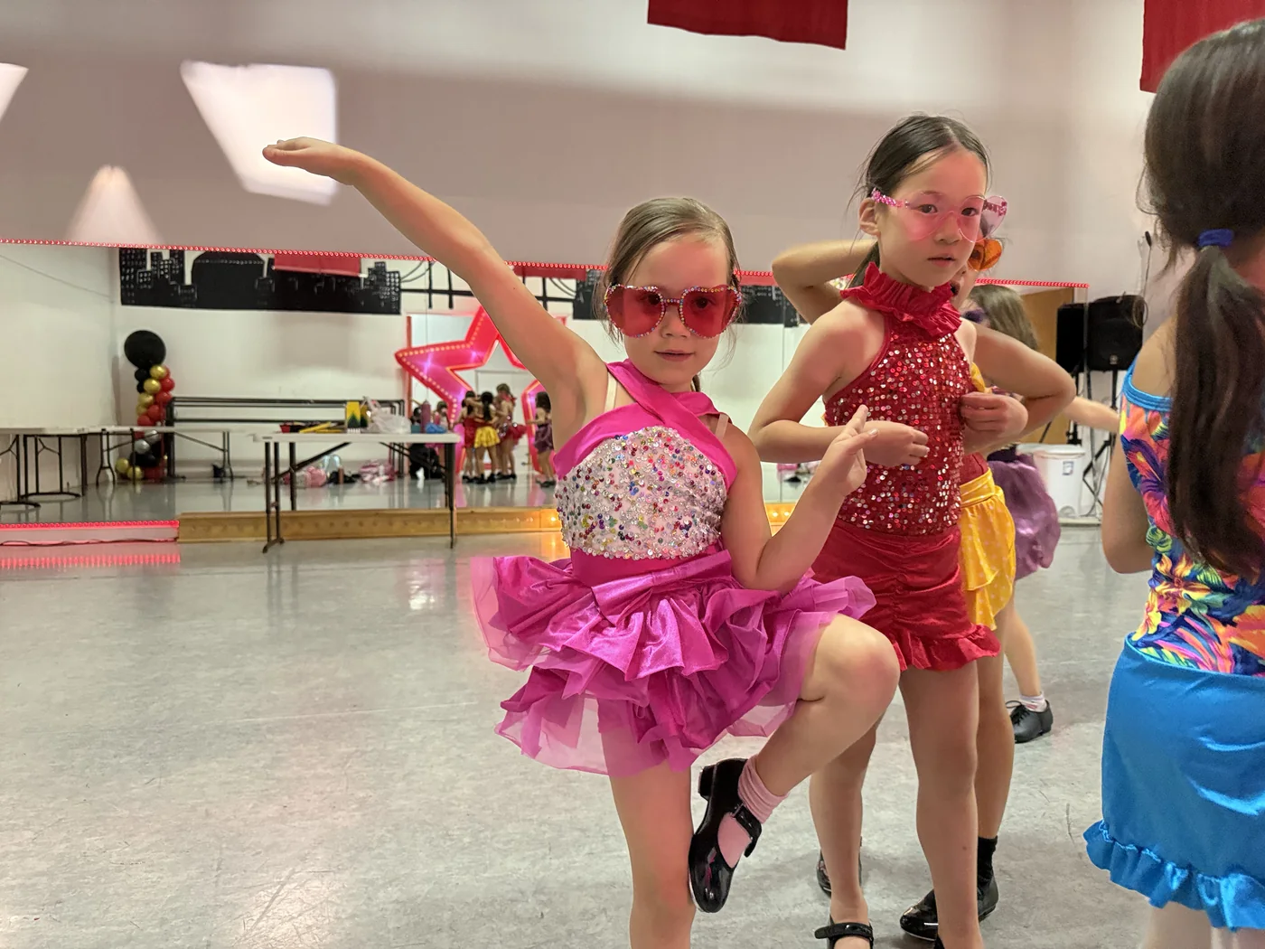 Young campers in pink tutus dancing together in the studio