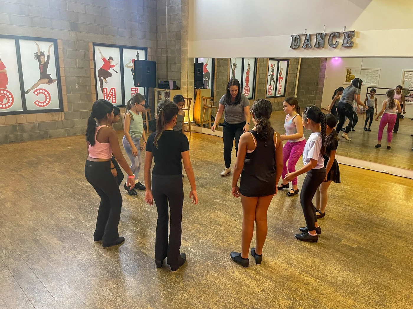 A studio full of dancers of mixed ages working through class together