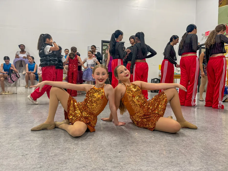 Tween and teen dancers rehearsing a routine together on the studio floor
